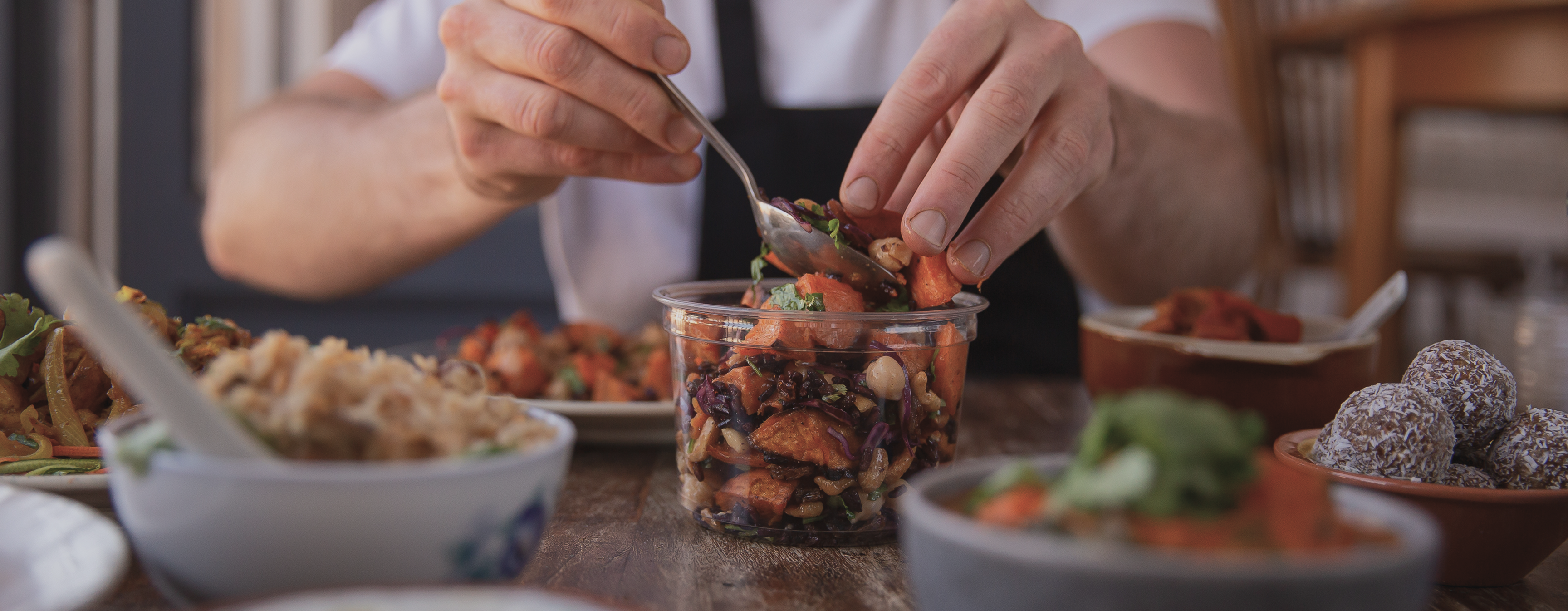 Chef in apron spooning berries and nut mix, representing the variety of service positions available at RDV Corp.